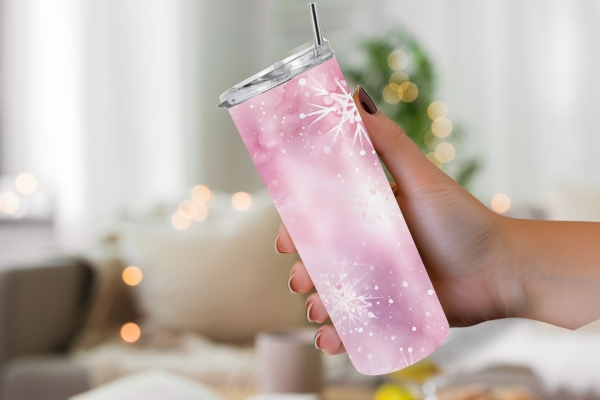 Rosa Thermobecher mit Schneeflockenmotiv, 590 ml Fassungsvermögen, in der Hand gehalten, vor einem gemütlichen, weihnachtlich dekorierten Hintergrund.